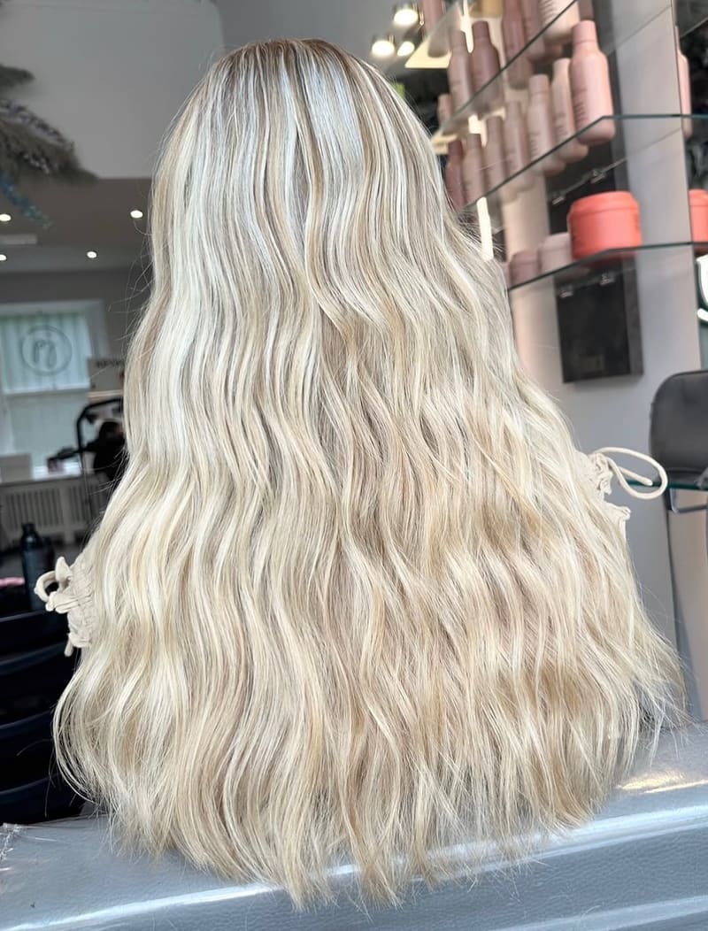 After: the same length in a bright, even icy blonde, waved.