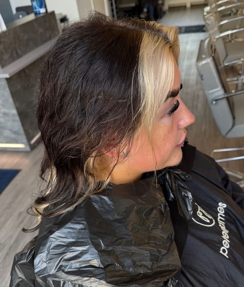 Before: short dark hair with a blonde streak at the front, in a colour cape.