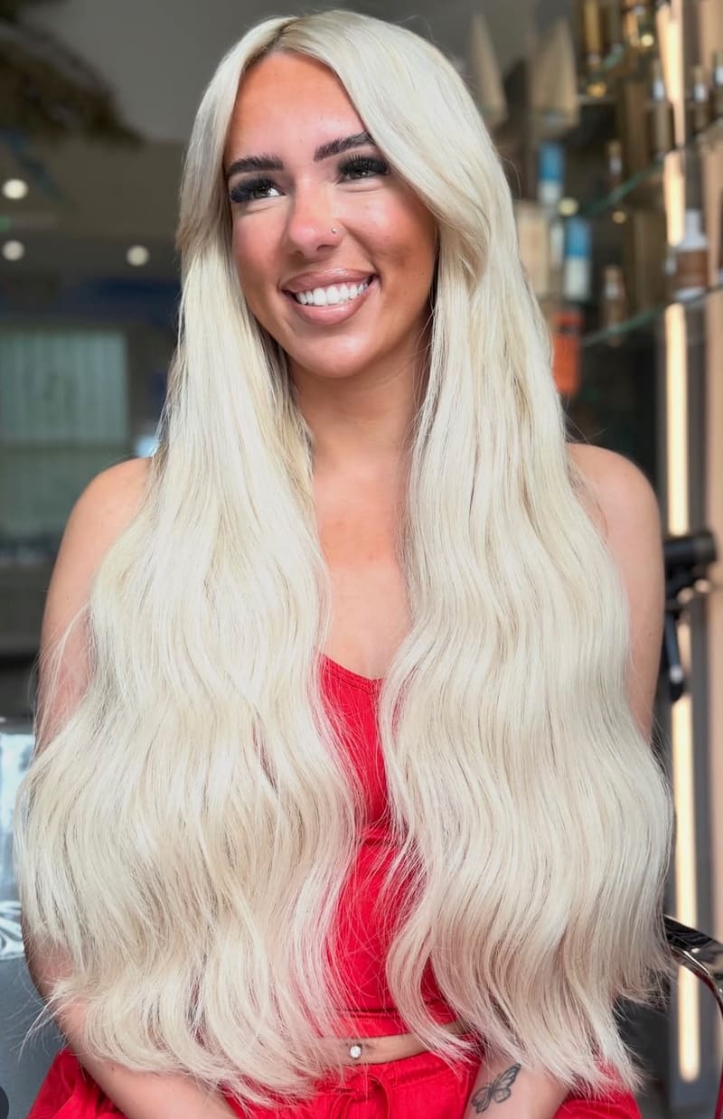 After: long, bright platinum hair with a soft wave.