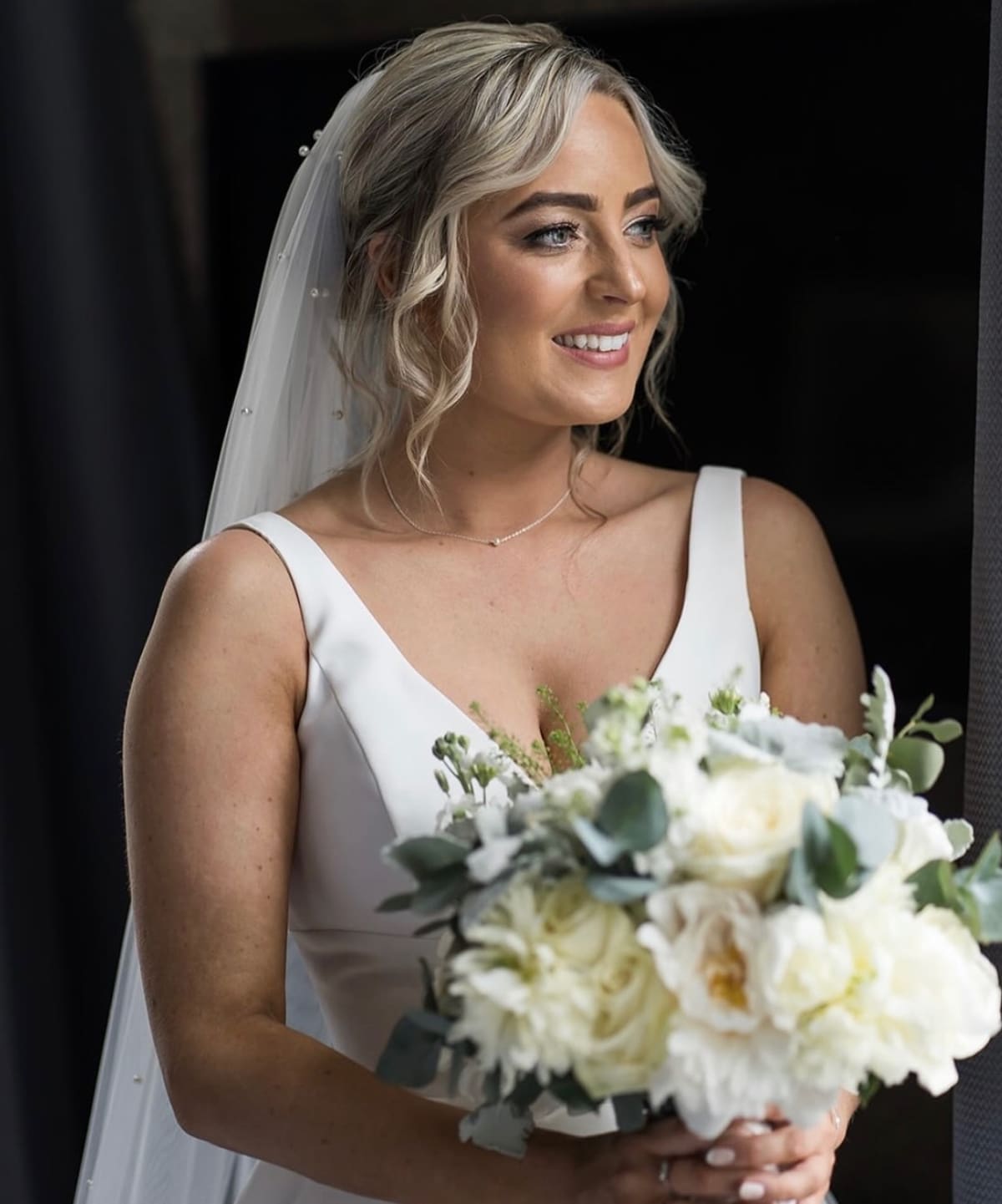 Bridal hair up with a veil and loose curls.
