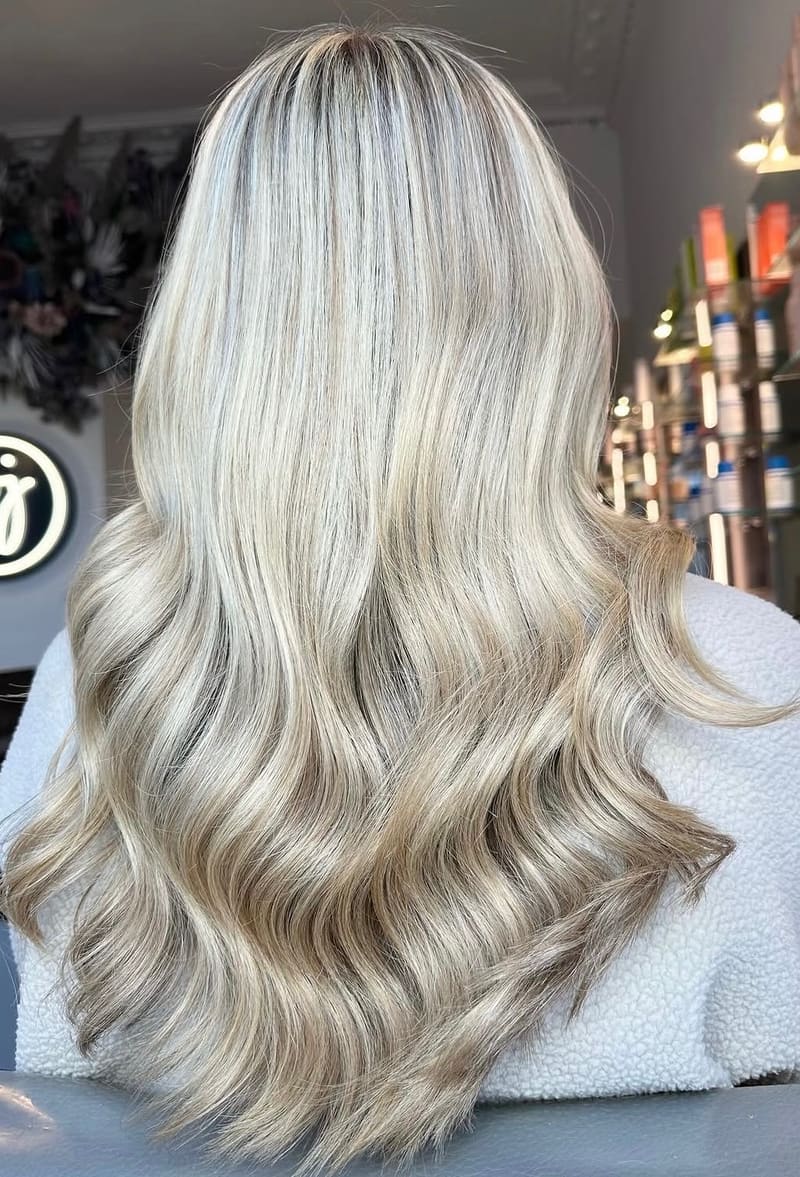 Icy blonde in tight curls, seen from behind.